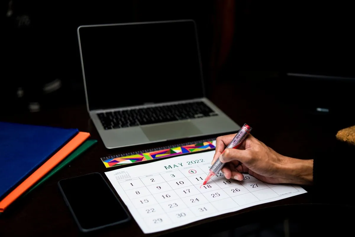 Un calendario da parete con alcune date segnate a penna sopra una scrivania