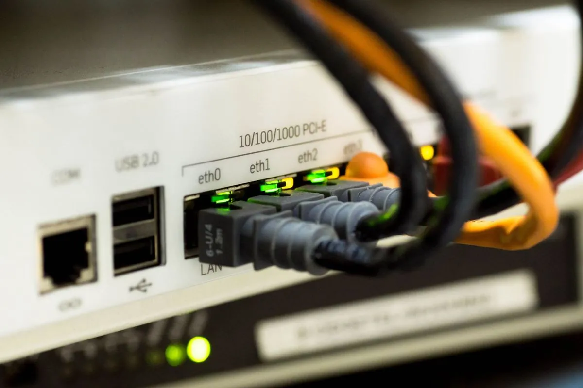 Un cavo di rete staccato davanti a un router con le spie accese