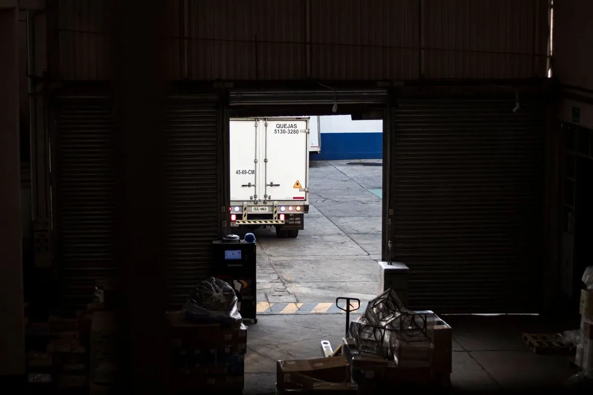Camion in carico alla banchina di un magazzino con i pallet pronti
